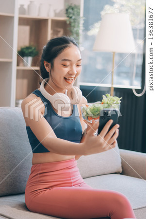 Fit young Asian women in activewear sitting on yoga mat and eating fresh vegetable salad after workout, representing clean eating, fitness lifestyle, wellness routine and health balance. Fit young Asian women in activewear sitting on yoga mat and eating fresh vegetable salad after workout, representing clean eating, fitness lifestyle, wellness routine and health balance. 136381677