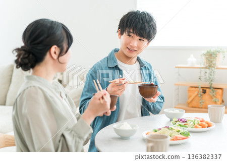 一對年輕的亞洲夫婦在家中餐桌上用餐。 一對年輕的亞洲夫婦在家中餐桌上用餐。 136382337