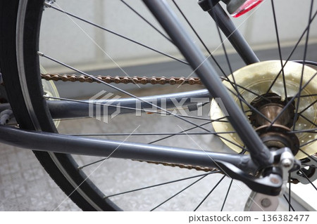 Rusty bicycle chain and rear wheel spokes 136382477