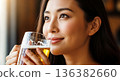 Close-up of a happy young woman enjoying a glass of cold beer. She is smiling. 136382660