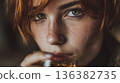 Intimate close-up of a young woman with red hair, freckles, and a drink. 136382735