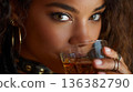 Close-up portrait of a young woman enjoying an alcoholic beverage, holding a glass. 136382790