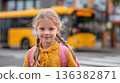 A cheerful blonde girl with pigtails and a pink backpack smiles, a yellow bus in the background. 136382871