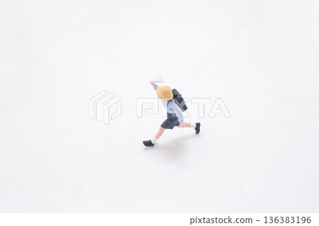 Miniature student runs forward across clean white studio background Miniature student runs forward across clean white studio background 136383196