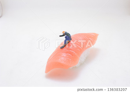 Miniature snowboarder descends slope of salmon sushi Miniature snowboarder descends slope of salmon sushi 136383207