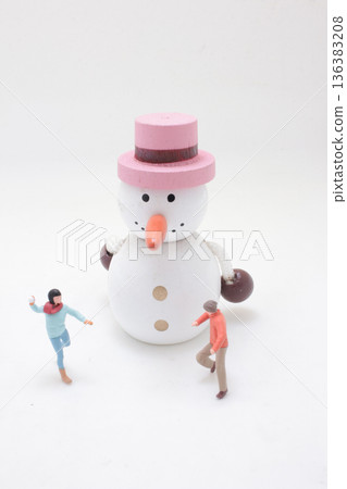 Miniature people play around large wooden snowman figure Miniature people play around large wooden snowman figure 136383208