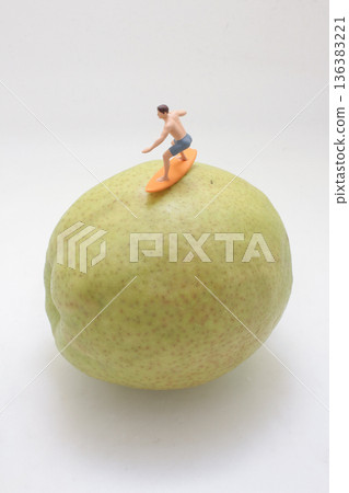 Miniature surfer rides imagined wave atop large pear Miniature surfer rides imagined wave atop large pear 136383221