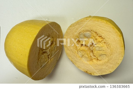 Half a string pumpkin on a white cutting board 136383665
