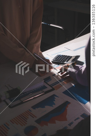 Above table with finance papers, graphs and big data during teamwork meeting with accounting or marketing team discussing budget, strategy or growth development. Closeup of SEO team doing research Above table with finance papers, graphs and big data during teamwork meeting with accounting or marketing team discussing budget, strategy or growth development. Closeup of SEO team doing research 136385116