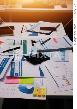 Above table with finance papers, graphs and big data during teamwork meeting with accounting or marketing team discussing budget, strategy or growth development. Closeup of SEO team doing research 136385124