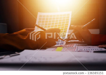 Team of uxui designers pointing at computer screen, discussing new mobile app design in the office 136385151