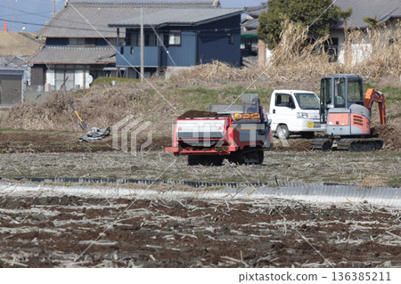 Spreading compost in lotus root fields 136385211