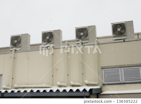 Snow-covered air conditioner outdoor unit 136385222