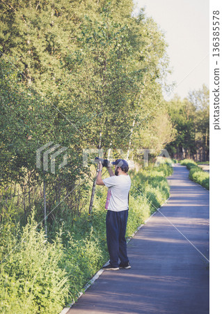 Photographer at work. A man takes pictures with a camera. Traveling photographer. 136385578