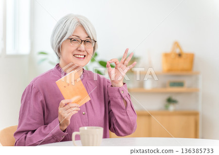 A gray-haired senior woman holding a pension book A gray-haired senior woman holding a pension book 136385733