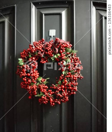 A wreath of red berries on the front door A wreath of red berries on the front door 136386483
