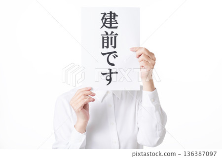 一名身穿白襯衫的人雙手拿著一張寫有「建前」字樣的紙。 136387097