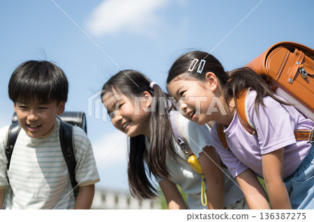 Smiling elementary school student (child) peering into the blue sky and school background - an exciting and fun image Smiling elementary school student (child) peering into the blue sky and school background - an exciting and fun image 136387275