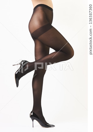 Slender female legs in black shaping pantyhose and high heel shoes Slender female legs in black shaping pantyhose and high heel shoes 136387360