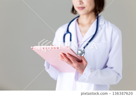 Middle-aged female nurse in a white coat Middle-aged female nurse in a white coat 136387620