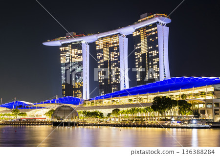 Night view of the Marina Bay Sands. This integrated resort fronts Marina Bay in Singapore. At night, there is an exhilarating music, light, and water dance show. 136388284