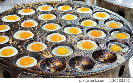 Cooking Multiple quail eggs in a hot pan 136388292