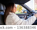 woman with long brown hair driver in a modern car. woman looks ahead at the road. Safe driving behavior and road trip. delivery, women's taxi 136388346
