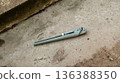 Adjustable pipe wrench lying on concrete surface. Tool for plumbing and repair work. Industrial instrument for construction and maintenance task. 136388350