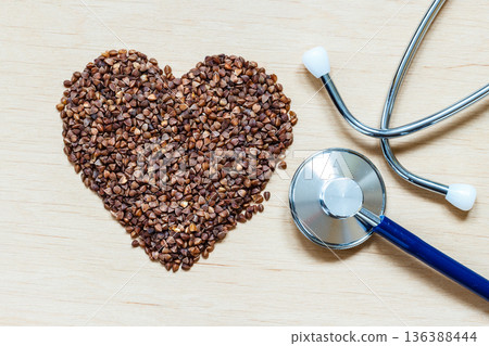 buckwheat groats heart shaped on wooden surface. buckwheat groats heart shaped on wooden surface. 136388444