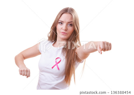 Woman wih pink ribbon on chest punching boxing Woman wih pink ribbon on chest punching boxing 136388454