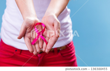 Woman with breast cancer awareness ribbon on hands Woman with breast cancer awareness ribbon on hands 136388455