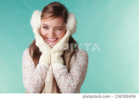 Smiling cute pretty woman girl in earmuffs. Smiling cute pretty woman girl in earmuffs. 136388456