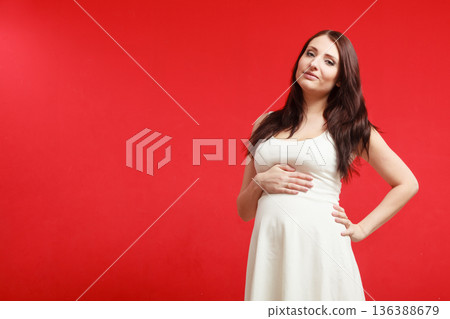 Standing pregnant woman in white dress 136388679
