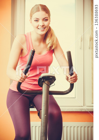 Woman working out on exercise bike. Fitness. 136388693