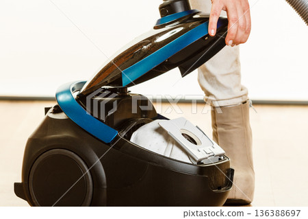 Woman opening vacuum cleaner. Woman opening vacuum cleaner. 136388697