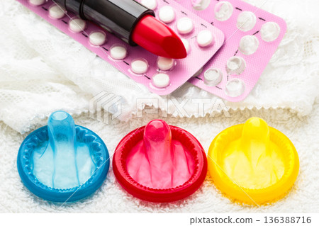 Pills condoms and lipstick on lace lingerie 136388716