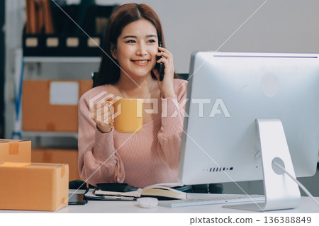 Starting small businesses SME owners female entrepreneurs check online orders to prepare to pack the boxes, sell to customers, sme business ideas online. Starting small businesses SME owners female entrepreneurs check online orders to prepare to pack the boxes, sell to customers, sme business ideas online. 136388849