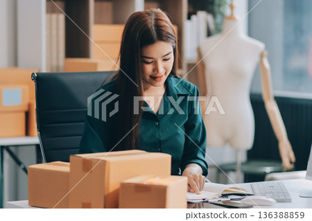 Starting small businesses SME owners female entrepreneurs check online orders to prepare to pack the boxes, sell to customers, sme business ideas online. 136388859