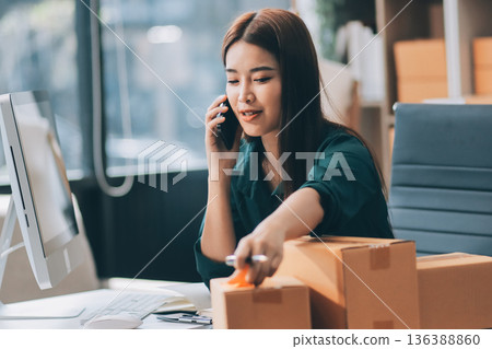 Starting small businesses SME owners female entrepreneurs check online orders to prepare to pack the boxes, sell to customers, sme business ideas online. 136388860