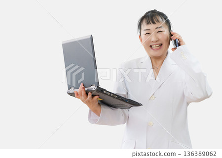 一位年輕女子，手上拿著電腦和智慧型手機 136389062