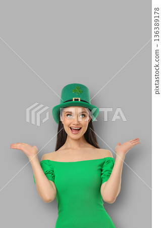 A young woman in a green outfit smiles and raises her hands A young woman in a green outfit smiles and raises her hands 136389178