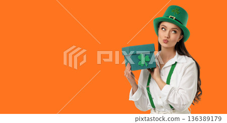A young woman poses with a gift box wearing a green costume 136389179
