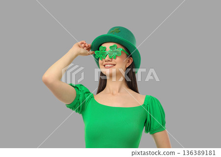 A young woman is wearing green clothing and fun glasses A young woman is wearing green clothing and fun glasses 136389181
