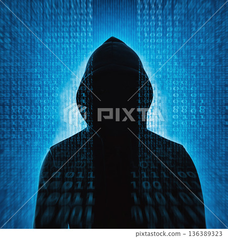 Dark figure in a hoodie stands in front of blue binary code representing digital technology and cyber security themes 136389323