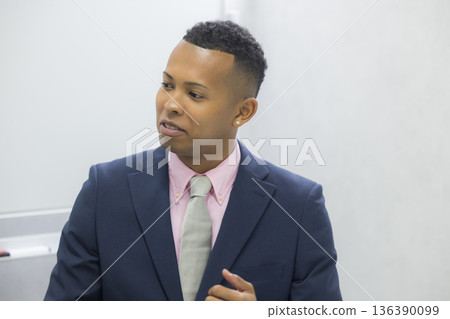 A man in a suit carrying a backpack 136390099