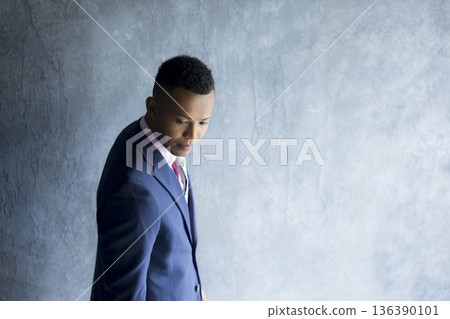 A man in a suit carrying a backpack 136390101