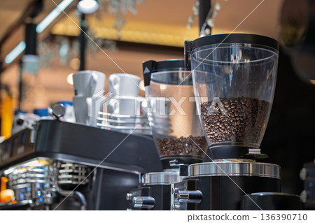 Coffee bean in coffee machine in coffee shop. Coffee shop equipment. Coffee maker and coffee grinder in coffee shop. Coffee bean in coffee machine in coffee shop. Coffee shop equipment. Coffee maker and coffee grinder in coffee shop. 136390710