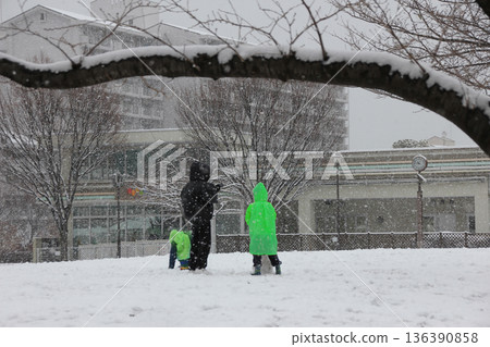 父子倆在雪地公園玩耍 136390858