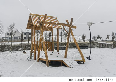 A snow-covered playground and a snow-covered playhouse on the kids' playground. The concept of winter and winter nature. A snow-covered playground and a snow-covered playhouse on the kids' playground. The concept of winter and winter nature. 136391178