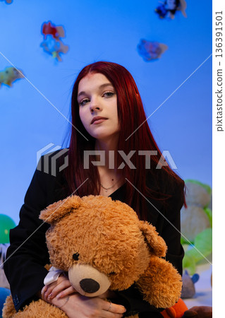 Close portrait of a young woman with a soft toy on colorful balloons background. Close portrait of a young woman with a soft toy on colorful balloons background. 136391501